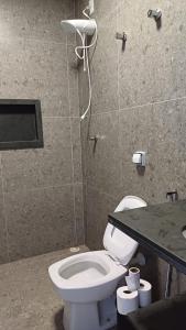 een badkamer met een wit toilet en een douche bij Sítio Vitória in Delfinópolis