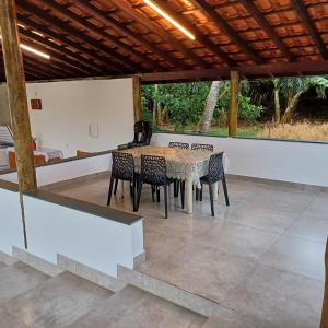 een patio met een tafel en stoelen onder een dak bij Sítio Vitória in Delfinópolis