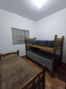 een slaapkamer met 2 stapelbedden en een raam bij Sítio Vitória in Delfinópolis