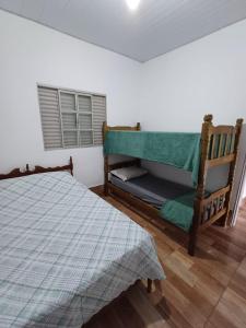 een slaapkamer met een bed en een raam bij Sítio Vitória in Delfinópolis