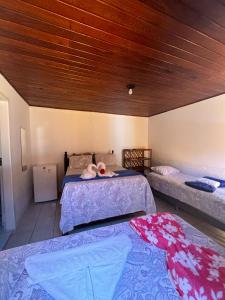een slaapkamer met 2 bedden en een houten plafond bij Pousada da Barra in Barra Grande