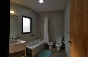 y baño con bañera, aseo y lavamanos. en Cabañas Norden San Pedro en San Pedro