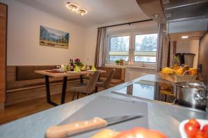 a kitchen and living room with a table and a dining room at Natura Aparts in Stanzach