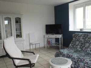 a living room with a couch and a tv at LES HAUTS VENTS in Saint-Pol-de-Léon