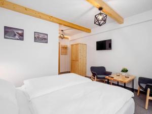 a bedroom with a bed and two chairs and a table at Studio Apartment with Mountain View in Zakopane