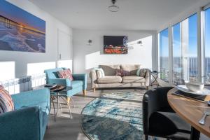 a living room with a couch and chairs and windows at 19 Undercliffe in Felixstowe