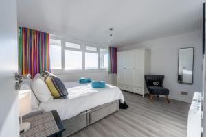 a bedroom with a large bed and a chair at 19 Undercliffe in Felixstowe