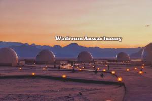 vista su un deserto con cupole e tramonto di Wadi rum anwar luxury camp a Wadi Rum