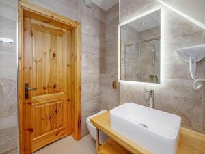 a bathroom with a white sink and a wooden door at Studio Apartment with Mountain View in Zakopane
