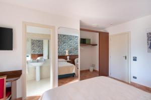 1 dormitorio con cama, lavabo y espejo en Hotel Rasinus en Roccaraso