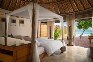 a bedroom with a bed and a view of the ocean at Banyan Tree Vabbinfaru in Male City