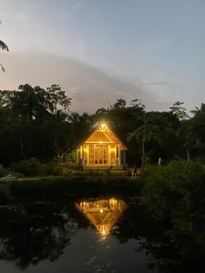 a house lit up at night next to a pond at Summer Bell Midigama in Midigama East