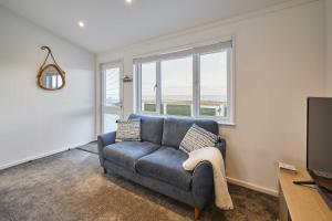 a living room with a blue couch and a window at Host & Stay - Sea View Road in Bessingby