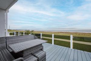 a bench on a porch with a view of the beach at Host & Stay - Sea View Road in Bessingby