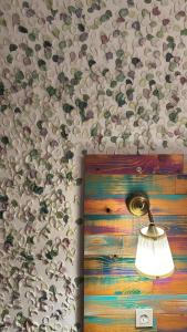 a lamp hanging on a wall with a painting at Boho House in Pakoštane