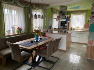 uma cozinha com uma mesa de madeira e cadeiras num quarto em Schmuckes Einfamilienwohnhaus em Spielberg