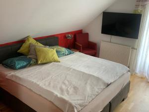 een slaapkamer met een groot bed en een televisie aan de muur bij Schmuckes Einfamilienwohnhaus in Spielberg