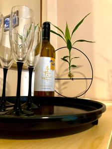 a bottle of wine and four wine glasses on a tray at Best Kept Secret by the Sea in Famagusta