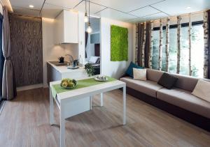 ein Wohnzimmer mit einem weißen Tisch und einem Sofa in der Unterkunft Camping Bergamini in Peschiera del Garda