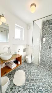 een badkamer met een douche, een wastafel en een toilet bij Boho House in Pakoštane