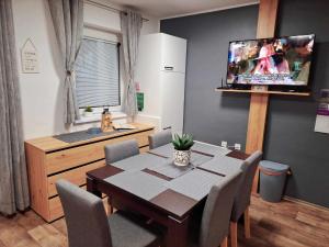 jadalnia ze stołem i telewizorem z płaskim ekranem w obiekcie Cherry House w mieście Čatež ob Savi