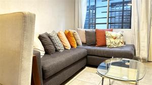 sala de estar con sofá y mesa de cristal en Fast WiFi • Wash/Dry • SoftBed • Parking • 24/7 Security, en Guadalajara