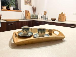 - un plateau avec 2 tasses et des assiettes sur un comptoir de cuisine dans l'établissement Pod Dębem, à Bartel Wielki