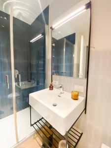 La salle de bains est pourvue d'un lavabo blanc et d'un miroir. dans l'établissement Dotcampus Roma City Center, à Rome