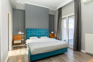 een slaapkamer met een bed en een blauwe muur bij #Apollo, Luxe Aristotelous penthouse, city view in Thessaloniki