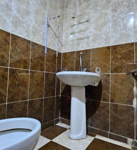 a bathroom with a white toilet and a sink at Comfy Hostel-Style Home Near Pyramids in Cairo
