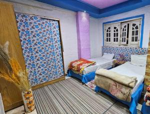 a room with two beds and a chair in it at Comfy Hostel-Style Home Near Pyramids in Cairo