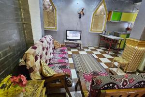 a living room with a couch and a tv at Comfy Hostel-Style Home Near Pyramids in Cairo
