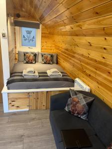 um quarto com uma cama e um sofá numa cabina em Bonnie Brae Pod em Fort William