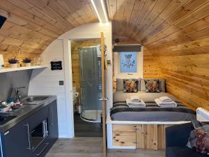 a small bedroom with a bed in a tiny house at Bonnie Brae Pod in Fort William