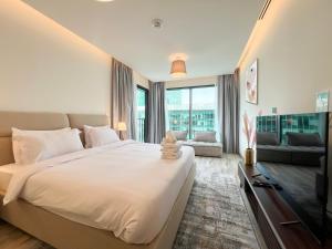 a bedroom with a large bed and a television at Luxury Studio with Unobstructed Burj Khalifa View - 23AB08 in Dubai