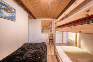 een slaapkamer met 2 stapelbedden en een bureau bij Chalet authentique en vallée verte in Bogève