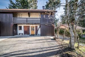 een oud huis met een veranda en een oprit bij Chalet authentique en vallée verte in Bogève