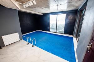 a large swimming pool in a room with blue walls at Bakhmaro Continent in Chʼkhakoura