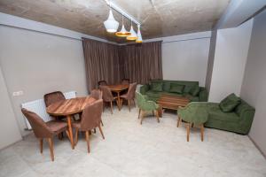 a room with tables and chairs and a green couch at Bakhmaro Continent in Chʼkhakoura