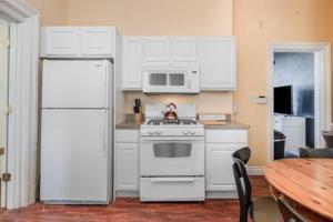 eine Küche mit einem weißen Kühlschrank und einem Tisch in der Unterkunft Downstairs 2 Bedroom Apt- Pet Friendly- walking distance to beach & shops in Michigan City