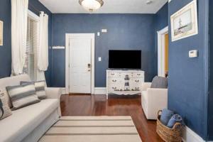 ein blaues Wohnzimmer mit einem Sofa und einem TV in der Unterkunft Downstairs 2 Bedroom Apt- Pet Friendly- walking distance to beach & shops in Michigan City