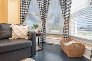 a living room with a couch and two windows at Beautiful downstairs 1bed 1bth charmer- Pet Friendly in Michigan City