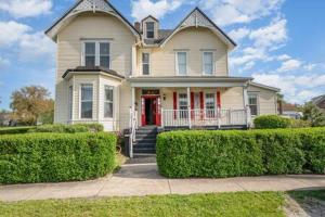 a house with a red door and some bushes at Spacious upstairs 1bed- Walking distance to Beach outlet mall in Michigan City