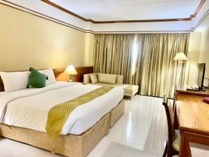 um quarto de hotel com duas camas e uma secretária em Kosa Hotel & Wellness Center -SHA Certified em Khon Kaen