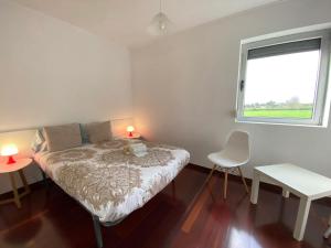 um pequeno quarto com uma cama e uma janela em Luz's Retreat Apartment em Ponta Delgada