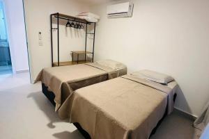 Cette chambre comprend deux lits installés dans une pièce avec dans l'établissement BlueCoast 205 Apartment, à Rio das Ostras