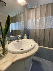 een badkamer met een witte wastafel en een douche bij Luz's Retreat Apartment in Ponta Delgada