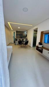 een woonkamer met een televisie en een eetkamer bij BlueCoast 205 Apartment in Rio das Ostras