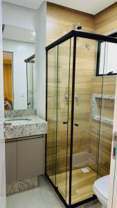y baño con ducha de cristal y aseo. en BlueCoast 205 Apartment, en Rio das Ostras