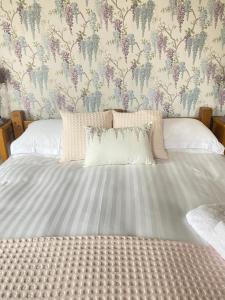 um quarto com uma cama grande e papel de parede floral em Sheriff Lodge em Matlock